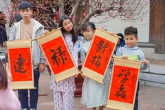 Các em nhỏ thích thú khi xin được chữ ở Văn Miếu-Quốc Tử Giám. (Ảnh: Khánh Hòa/TTXVN)