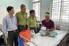 Lãnh đạo Chi cục Kiểm lâm Đồng Nai thăm hỏi, động viên kiểm lâm viên của Vườn Quốc gia Cát Tiên tại bệnh viện. (Ảnh: TTXVN phát)