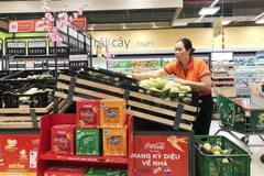 Nhân viên siêu thị Thành phố Hồ Chí Minh bổ sung thêm hàng hóa lên quầy, kệ vào sáng 23/1. (Ảnh: Mỹ Phương/TTXVN)