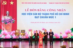 Giám đốc Học viện Chính trị Quốc gia Hồ Chí Minh Nguyễn Xuân Thắng trao Bằng công nhận đạt chuẩn mức 1 cho Học viện Cán bộ Thành phố Hồ Chí Minh. (Ảnh: Tiến Lực/TTXVN)