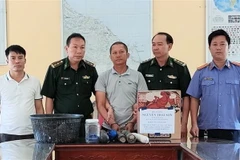 Đối tượng cùng tang vật vụ án. (Ảnh: TTXVN phát)