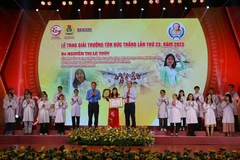 Phó Chủ tịch Tổng Liên đoàn Lao động Việt Nam Huỳnh Thanh Xuân (trái) cùng ông Nguyễn Hồ Hải, Phó Bí thư Thành ủy trao giải cho chị Nguyễn Thị Lệ Thủy, Tổ trưởng Tổ nuôi động vật thí nghiệm Trung tâm Công nghệ Sinh học Thành phố Hồ Chí Minh. (Ảnh: Thanh V