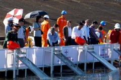 Các đại biểu thả cá xuống lòng hồ thủy điện Sông Tranh 2. (Ảnh: Trịnh Bang Nhiệm/TTXVN)