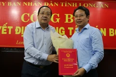 Phó Chủ tịch UBND tỉnh Long An Nguyễn Minh Lâm trao Quyết định bổ nhiệm Phó Giám đốc Sở Xây dựng cho ông Võ Anh Linh. (Ảnh: Thanh Bình/TTXVN)