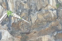 Nhà thầu di chuyển đất đá khỏi khu vực sạt lở. (Ảnh: TTXVN phát)