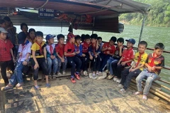 Các em học sinh làng Bèo Bọt, xã Cẩm Thành, huyện miền núi Cẩm Thủy, tỉnh Thanh Hóa phải đi thuyền vượt sông Mã. (Ảnh: Nguyễn Nam/TTXVN)