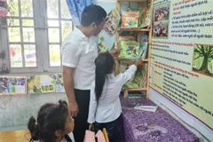 Học sinh điểm trường Ia Jip, trường Tiểu học Trần Quốc Tuấn, xã Chư Drăng, huyện Krông Pa, tỉnh Gia Lai chọn sách, truyện tại Tủ sách Đinh Hữu Dư. (Ảnh: Hồng Điệp/TTXVN)