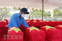 Đưa hài cốt liệt sỹ ra nơi cải táng. (Ảnh: Công Mạo/TTXVN)