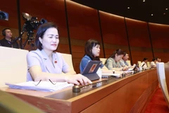 Đoàn đại biểu Quốc hội tỉnh Quảng Ninh ấn biểu quyết qua Luật Giao dịch điện tử (sửa đổi). (Ảnh: Doãn Tấn/TTXVN)