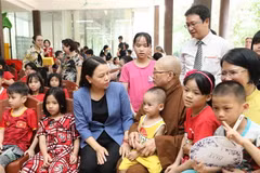 Phó Chủ tịch-Tổng Thư ký Ủy ban Trung ương Mặt trận Tổ quốc Việt Nam Nguyễn Thị Thu Hà thăm hỏi trẻ mồ côi tại chùa. (Ảnh: Minh Đức/TTXVN)