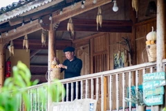 Trưởng thôn Sình Dỉ Gai trang trí homestay của gia đình. (Ảnh: Nam Thái/TTXVN)