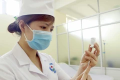Chuẩn bị lấy vaccine phòng COVID-19 trước khi tiêm. (Ảnh: Hoàng Hùng/TTXVN)