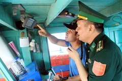 Lắp đặt thiết bị giám sát hành trình trên tàu cá. (Ảnh: Thế Duyệt/TTXVN)