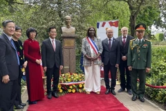 Các đại biểu chụp ảnh lưu niệm bên tượng đài Bác Hồ. (Ảnh: Nguyễn Thu Hà/TTXVN)