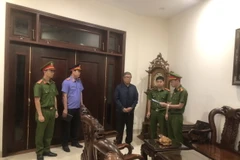 Cảnh sát điều tra Công an thành phố Đà Nẵng tống đạt các quyết định khởi tố bị can, ra lệnh bắt tạm giam đối với ông Đoàn Quang Vinh - nguyên Hiệu trưởng Trường Đại học Bách khoa Đà Nẵng. (Ảnh: TTXVN phát)