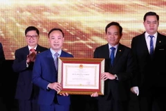 Phó Thủ tướng Trần Lưu Quang (bên phải) trao Huân chương Lao động hạng Nhì của Chủ tịch nước tặng Học viện Tư pháp. (Ảnh: Phạm Kiên/TTXVN)