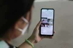 Một người vay nợ 'tín dụng đen' bị đăng ảnh kèm thông tin lên mạng xã hội để tạo áp lực trả tiền. (Ảnh: Giang Phương/TTXVN)