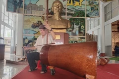 Nghệ nhân Võ Văn Bá sử dụng nhạc cụ đờn cò làm từ gốc dừa lớn nhất Việt Nam. (Ảnh: Huỳnh Phúc Hậu/TTXVN)