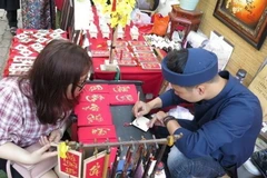 Xin chữ đầu năm ở Văn Miếu. (Ảnh: TTXVN)