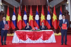 Thủ tướng Phạm Minh Chính và Thủ tướng Lào Sonexay Siphandone chứng kiến lễ ký Hiệp định tương trợ tư pháp dân sự giữa Việt Nam và Lào. (Ảnh: Dương Giang/TTXVN)