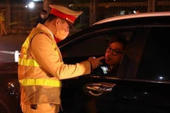 Kiểm tra nồng độ cồn của tài xế. (Ảnh: Phạm Kiên/TTXVN)
