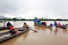 Lực lượng chức năng tổ chức tìm kiếm thi thể hai nam sinh mất tích còn lại. (Ảnh: TTXVN phát)