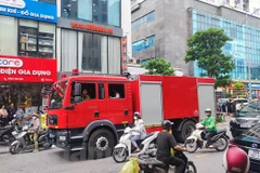 Lực lượng chức năng có mặt để khống chế đám cháy. (Ảnh: Hoài Nam/Vietnam+)