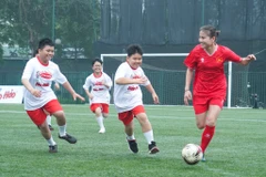 Tuyển thủ Bóng đá Nữ Thái Thị Thảo (áo đỏ) trong trận giao hữu với các bạn nhỏ thuộc Làng trẻ em SOS. (Ảnh: Việt Anh/Vietnam+)
