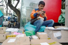 Các shipper (người giao hàng) đang 'bơi' trong đơn hàng trong những ngày cuối năm. (Ảnh: Việt Anh/Vietnam+)