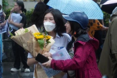 Phụ huynh chờ đón con em với bó hoa tươi thắm. (Ảnh: PV/Vietnam+)