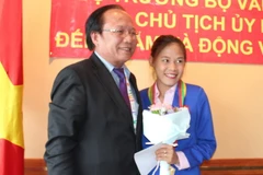 Bộ trưởng Hoàng Tuấn Anh trao lại huy chương vàng SEA Games 27 cho vận động viên đi bộ Nguyễn Thị Thanh Phúc. (Ảnh: Việt Hải-Lê Hải/Vietnam+)