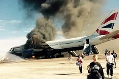 Hành khách cố tình cầm hành lý khi di tản khỏi máy bay. (Nguồn: independent)