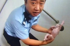 Bức ảnh chụp lại khoảnh khắc Qian Feng cứu bé gái. (Nguồn: AFP)