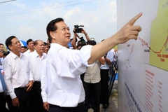 Thủ tướng Nguyễn Tấn Dũng xem sơ đồ quy hoạch Dự án cấp điện lưới Quốc gia cho xã đảo Lại Sơn. (Ảnh: Huy Hùng/TTXVN)