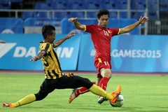 U23 Malaysia (áo vàng đen) đối mặt nguy cơ bị loại sớm. (Ảnh: Quốc Khánh/TTXVN)