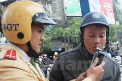 Cảnh sát giao thông tiến hành đo nồng độ cồn của người điều khiển phương tiện. (Ảnh: Việt Hùng/Vietnam+)