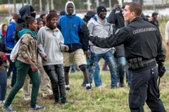 Cảnh sát cố gắng ngăn cản những người di cư tiếp cận đường đường ray tại Coquelles gần Calais. (Nguồn: AFP)