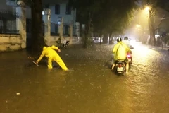 Nhân viên môi trường đô thị ứng trực mở cống thoát nước. (Ảnh: Lâm Khánh/TTXVN)