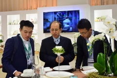 Ông Lý Ngọc Minh (đứng giữa) giới thiệu sản phẩm gốm sứ Minh Long I tại Triển lãm Ambiente - hội chợ thương mại về ngành sứ lớn nhất châu Âu. (Ảnh: TTXVN phát)