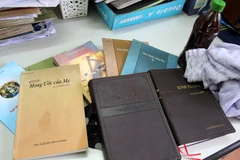 Tài liệu truyền đạo và cái gọi là ''nước thánh'' của Hội thánh của Đức Chúa Trời Mẹ. (Ảnh: Tư liệu do Công an Lai Châu cung cấp/TTXVN phát)