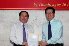 Ông Mai Văn Chính, Phó Trưởng ban Tổ chức Trung ương, trao quyết định của Ban Bí thư về công tác cán bộ cho ông Lê Tiến Châu. (Ảnh: Duy Khương/TTXVN)