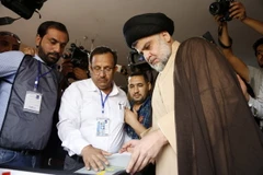 Thủ lĩnh cộng đồng người Hồi giáo dòng Shiite Moqtada al-Sadr (giữa, phải) bỏ phiếu tại điểm bầu cử ở thành phố Najaf ngày. (Nguồn: AFP/TTXVN)