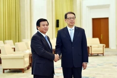Bí thư Trung ương Đảng Nguyễn Xuân Thắng và ông Trần Hy bắt tay thân mật. (Ảnh: Lương Tuấn/Vietnam+)