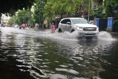Mưa lớn gây ngập tại đường Thanh Loan (Quận 8), khiến phương tiện lưu thông khó khăn. (Ảnh: Anh Tuấn/TTXVN)