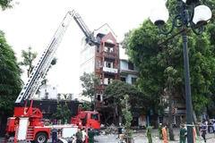Lực lượng Phòng cháy Chữa cháy và Cứu nạn Cứu hộ sử dụng xe thang chuyên dụng để tiếp cận hiện trường vụ nổ. (Ảnh: Phạm Kiên/TTXVN)