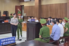 Bị cáo Phạm Thị Hằng, nguyên Giám đốc Sở giáo dục và đào tạo tỉnh Thanh Hóa được áp giải ra trước tòa. (Ảnh: TTXVN phát)