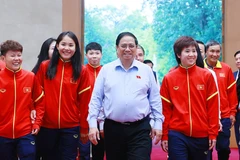 Thủ tướng Phạm Minh Chính tặng hoa cho các cầu thủ Đội tuyển Bóng đá Nữ Quốc gia Việt Nam. (Ảnh: Dương Giang/TTXVN)