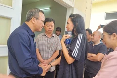 Ông Khuất Việt Hùng (áo đen), Phó Chủ tịch Chuyên trách Ủy ban An toàn Giao thông Quốc gia cùng ông Nguyễn Hữu Quế, Phó Chủ tịch Ủy ban Nhân dân tỉnh Gia Lai đến thăm hỏi, động viên vợ cầu thủ Paollo Madeira Oliveira. Ảnh: Quang Thái/TTXVN)