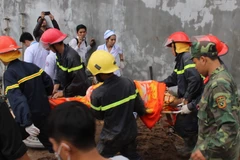 Lực lượng cứu hộ đưa nạn nhân ra ngoài. (Ảnh: Nguyên Lý/TTXVN)