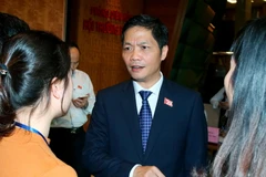 Phóng viên phỏng vấn Bộ trưởng Bộ Công Thương Trần Tuấn Anh trong giờ giải lao. (Ảnh: Thống Nhất/TTXVN)